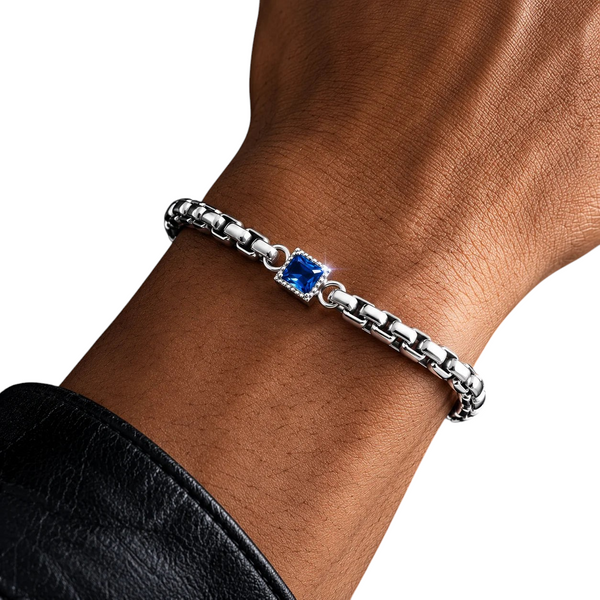 Aureliss Rex Armband aus Edelstahl mit quadratischen Gliedern und blauem Zirkonia-Anhänger am Handgelenk