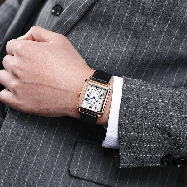 Aureliss Felix Quarzuhr mit rechteckigem roségoldenem Gehäuse, römischen Ziffern und schwarzem Lederarmband am Handgelenk