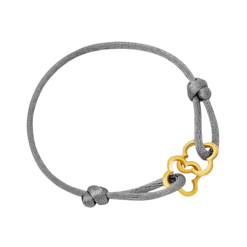Aureliss geflochtenes graues Textilarmband mit einem eleganten, goldfarbenen Kleeblatt-Anhänger und Knotenverschluss.
