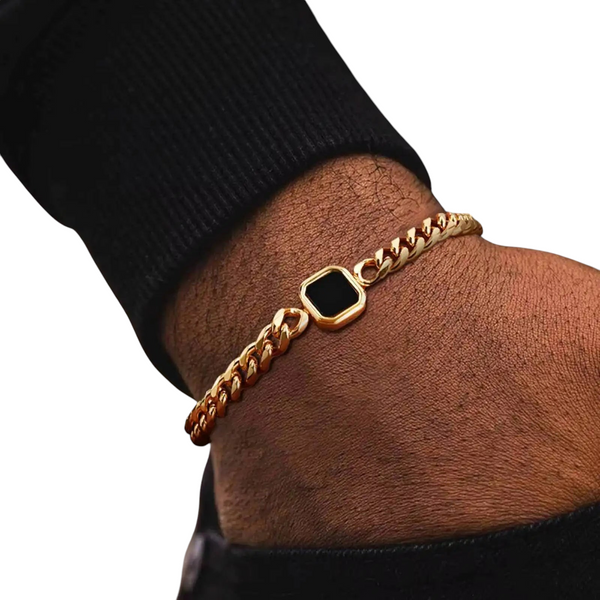 Aureliss Havana Panzerarmband aus goldfarbenem Edelstahl mit schwarzem quadratischem Element am Handgelenk